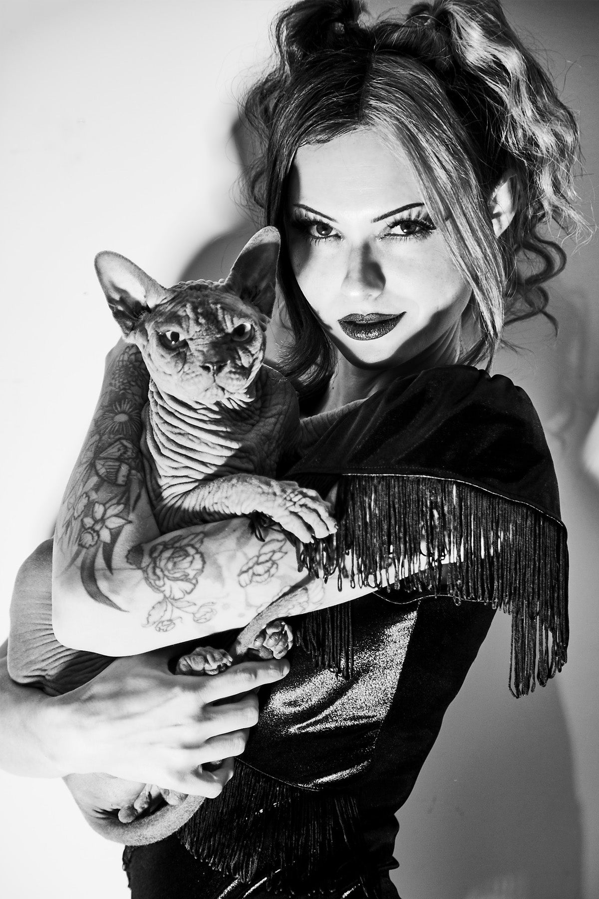 Black and white photo of a woman holding a Sphynx cat
